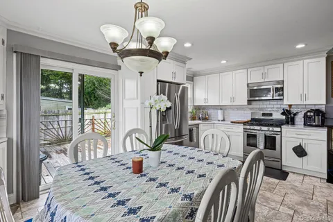 a dining room with furniture a chandelier and wooden floor