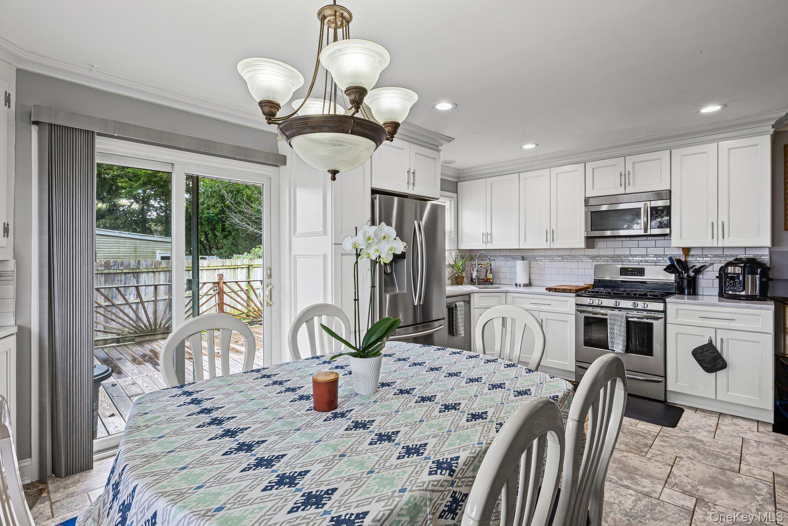 22 Larry Road Selden, NY 11784 - Photo 10 of 36 a kitchen with kitchen island granite countertop a center island a stove cabinets a dining table and chairs