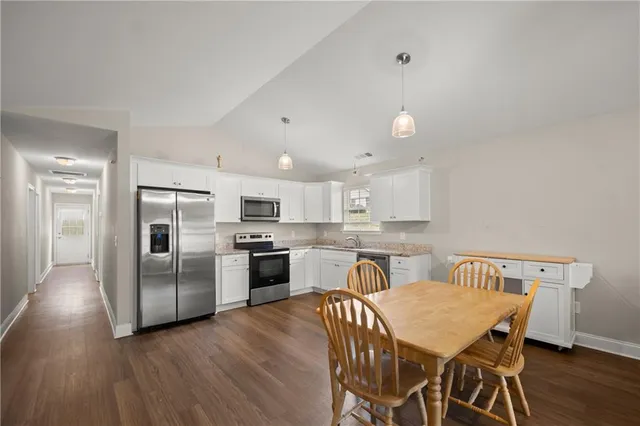 a kitchen with refrigerator cabinets dining table and chairs