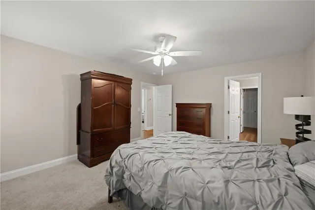 a bedroom with a bed and a lamp on a dresser