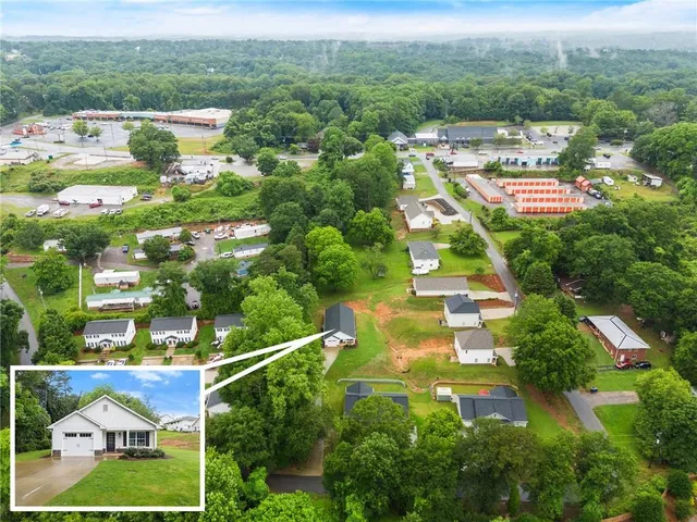 an aerial view of residential houses with outdoor space and street view
