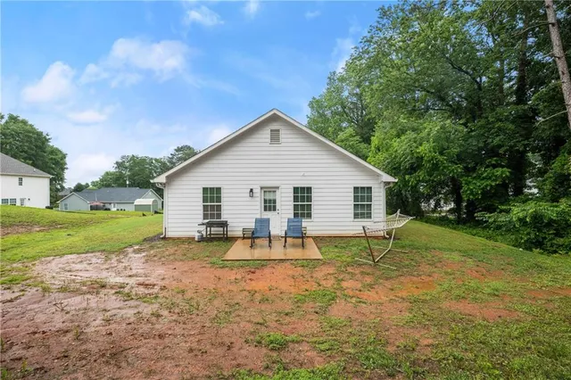 a view of a house with a yard and sitting area