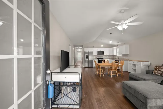 a living room with furniture a flat screen tv and kitchen view