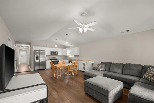 a living room with furniture kitchen view and a refrigerator