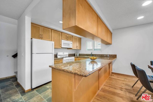 a kitchen with stainless steel appliances granite countertop a sink and a refrigerator