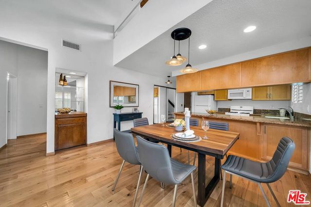 a dining room with stainless steel appliances kitchen island a table and chairs