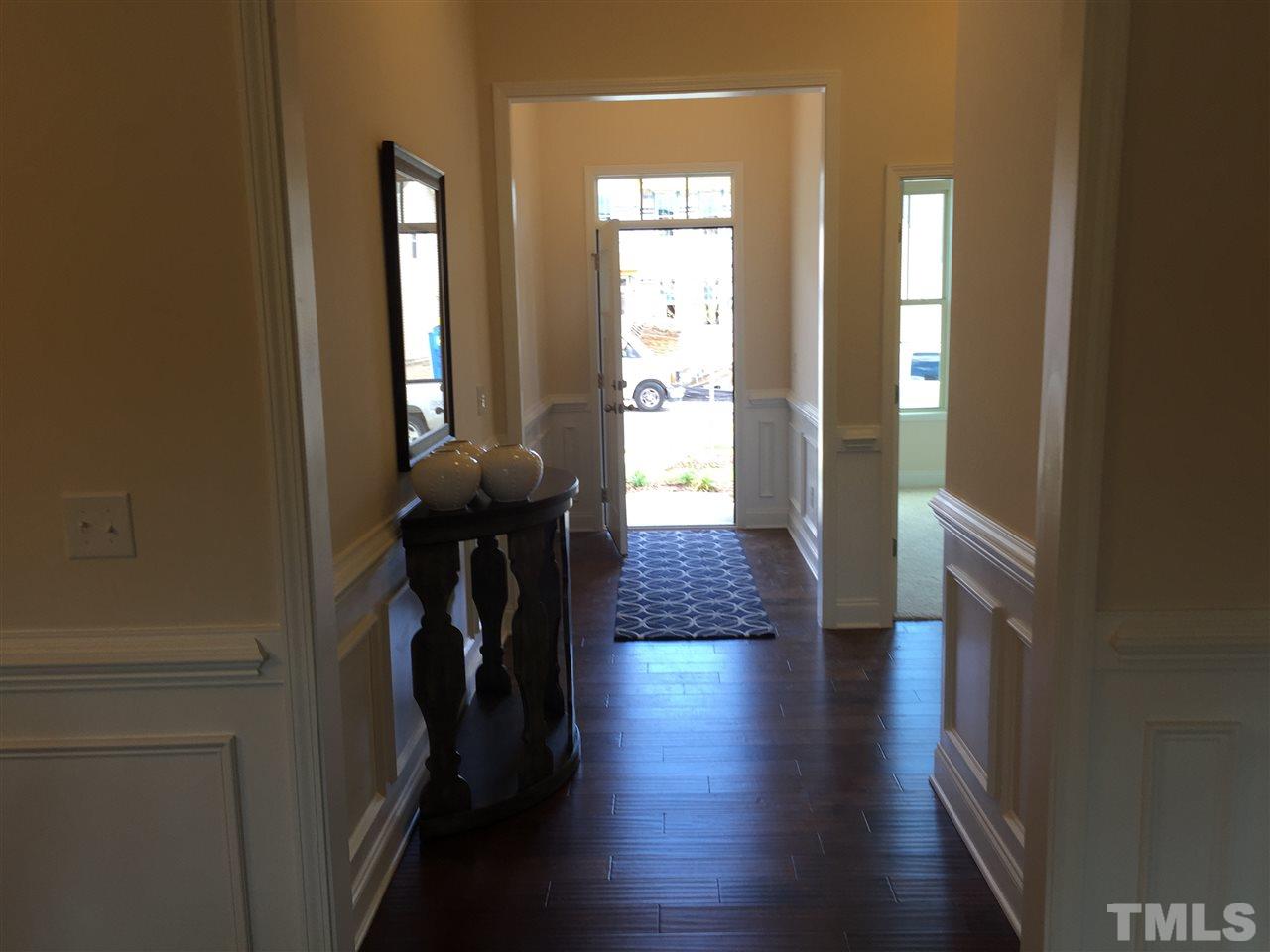 7463 Randshire Way Raleigh, NC 27616 - Photo 11 of 25 a view of a hallway with wooden floor and stairs