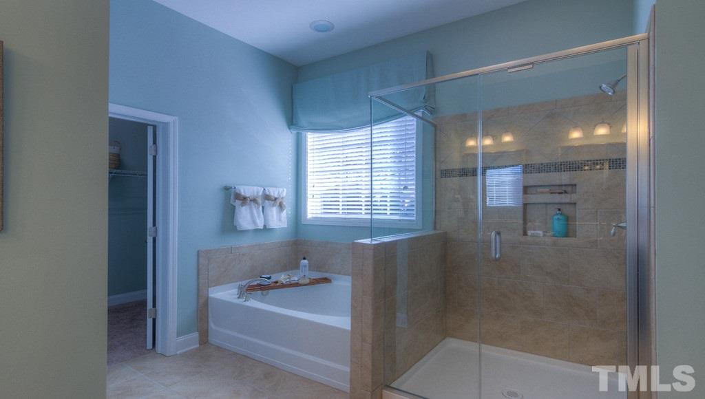 7463 Randshire Way Raleigh, NC 27616 - Photo 4 of 25 a bathroom with a bathtub and a shower