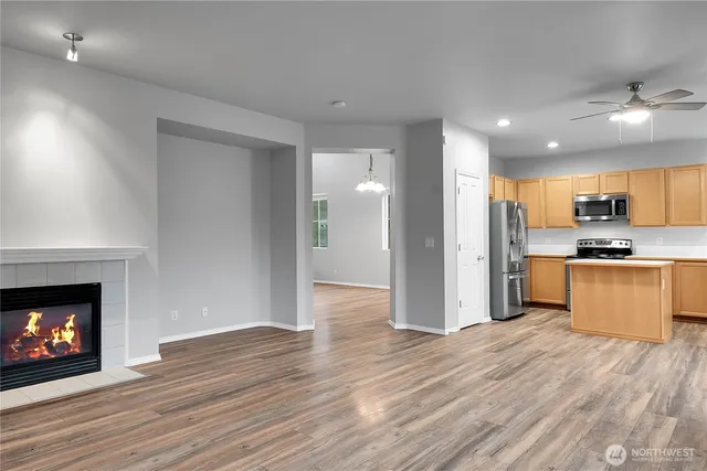 a view of kitchen with refrigerator microwave and stove with wooden floor