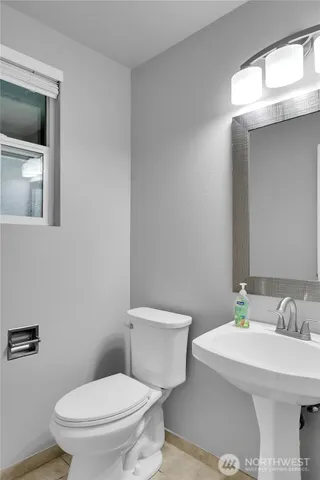 a bathroom with a toilet a sink and mirror