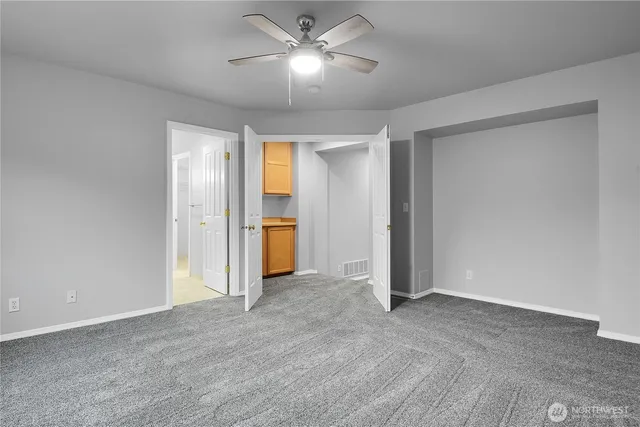 a view of empty room with a ceiling fan and window