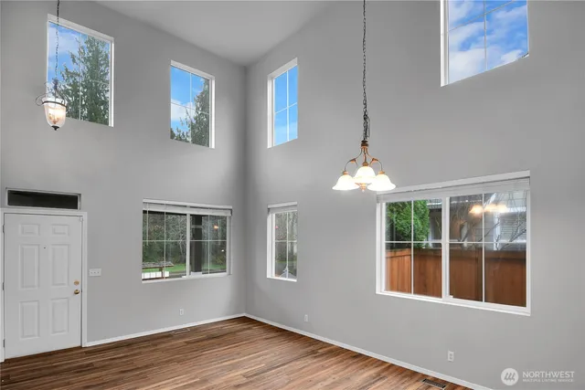 a view of a bedroom with wooden floor and windows