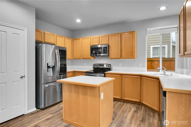 a kitchen with stainless steel appliances granite countertop a refrigerator sink and microwave