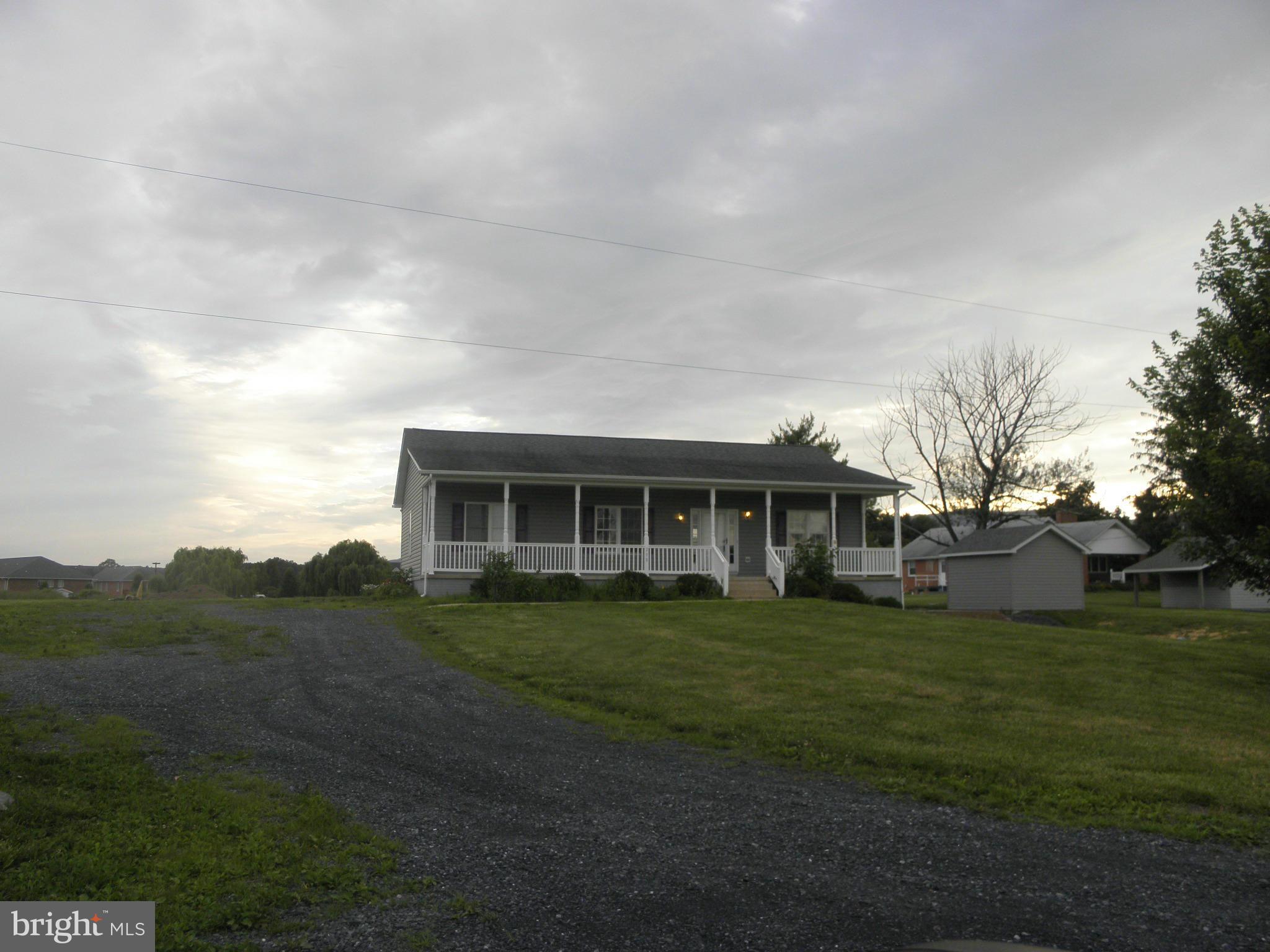 a view of a house with a big yard and large trees