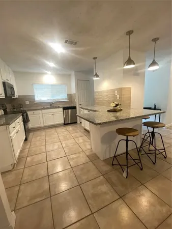 a kitchen with stainless steel appliances kitchen island granite countertop a sink and cabinets