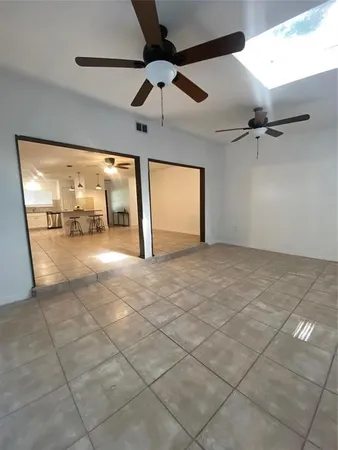 an empty room with windows and fan