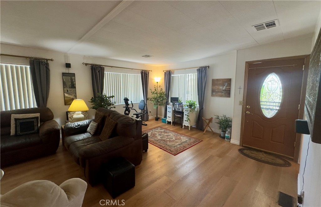 8651 Foothill Boulevard, Unit 18 Rancho Cucamonga, CA 91730 - Photo 6 of 12 a living room with furniture potted plant and a window