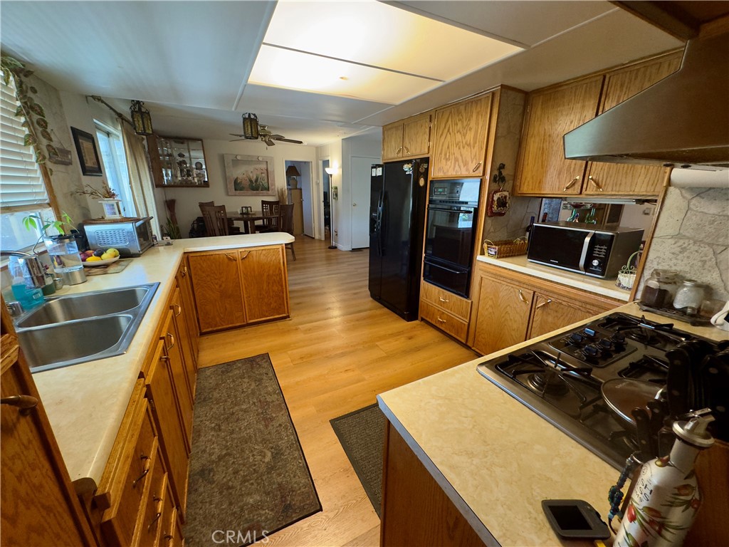 8651 Foothill Boulevard, Unit 18 Rancho Cucamonga, CA 91730 - Photo 7 of 12 a kitchen with stainless steel appliances granite countertop a refrigerator and a stove top oven