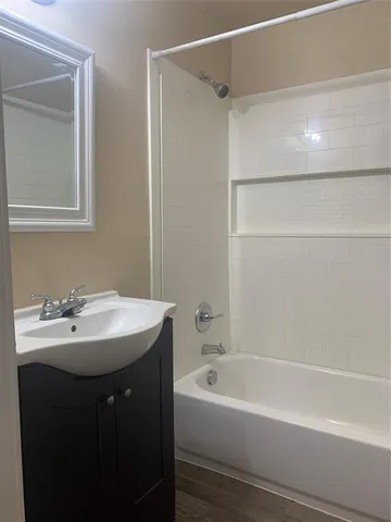 an empty room with chandelier fan and windows