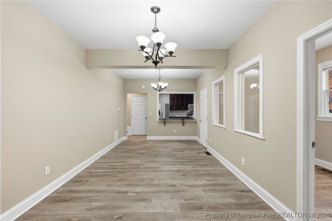 3204 Hickory Road Raleigh, NC 27616 - Photo 20 of 49 a view of a hallway with wooden floor and a chandelier