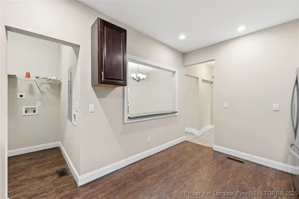 an empty room with wooden floor and entryway