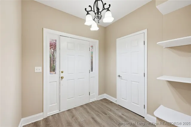 a view of a hallway with wooden floor and closet