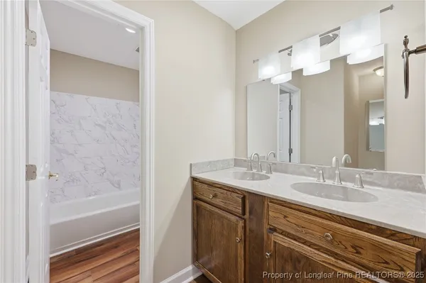 a bathroom with a granite countertop sink a mirror and a shower