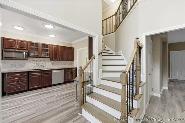 a kitchen with stainless steel appliances kitchen island granite countertop a refrigerator and a sink