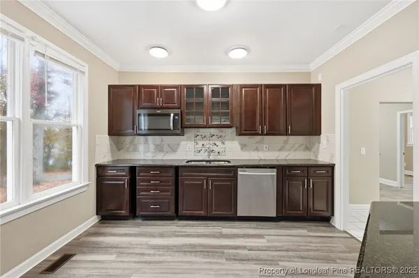 a kitchen with stainless steel appliances granite countertop a stove and cabinets