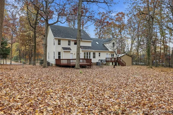 a front view of a house with a yard and a tree