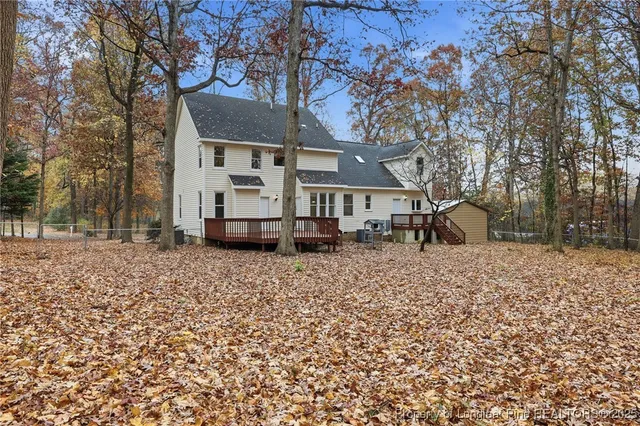 a front view of a house with a yard and a tree