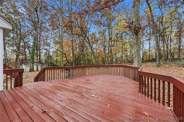 a balcony with wooden floor and trees