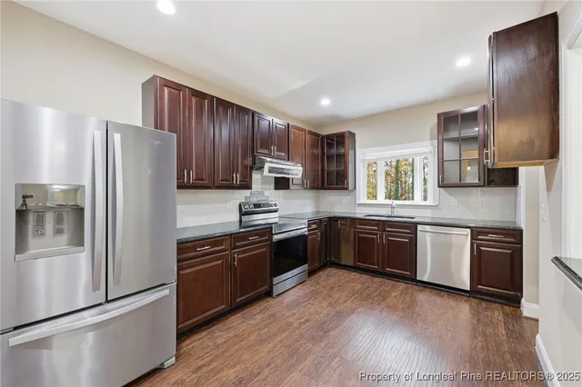 a kitchen with granite countertop stainless steel appliances and wooden cabinets