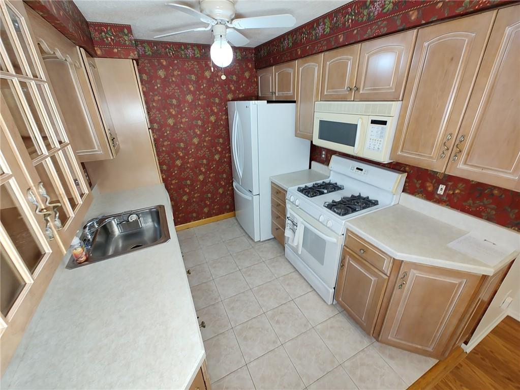 7448 Lighthouse Point Pittsburgh, PA 15221 - Photo 14 of 36 a kitchen with a stove and a refrigerator