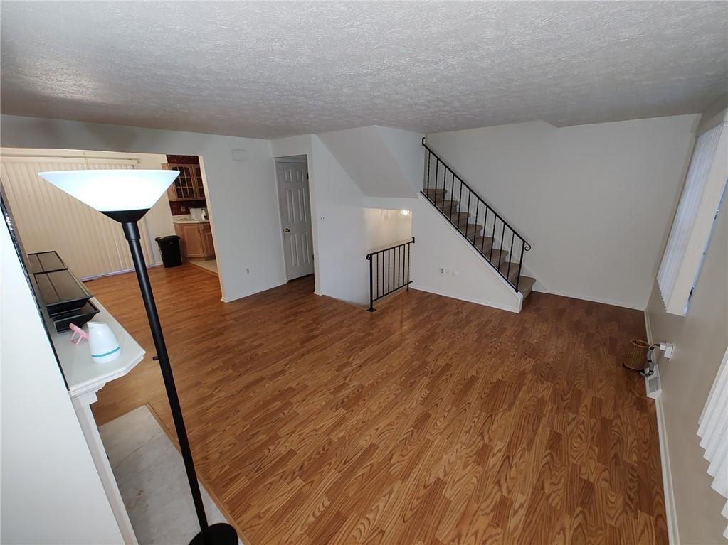 7448 Lighthouse Point Pittsburgh, PA 15221 - Photo 4 of 36 a view of a livingroom with wooden floor and stairs