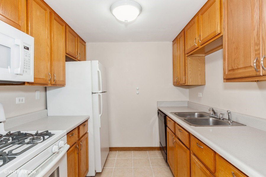 238 East Bailey Road, Unit M Naperville, IL 60565 - Photo 5 of 10 a kitchen with stainless steel appliances granite countertop a sink stove and refrigerator