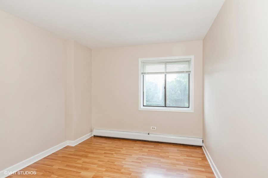 238 East Bailey Road, Unit M Naperville, IL 60565 - Photo 8 of 10 a view of an empty room with wooden floor and a window