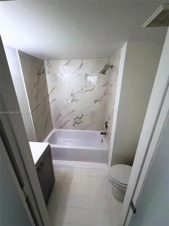 a bathroom with a tub and toilet