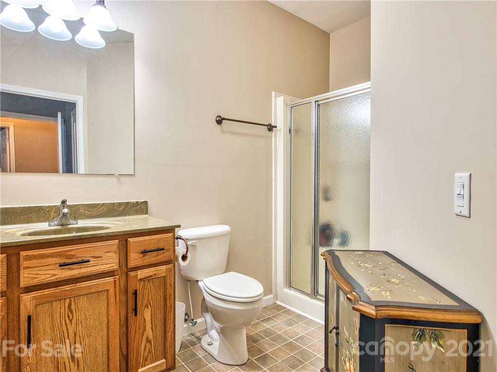94 Bayless Farm Road Canton, NC 28716 - Photo 22 of 24 a bathroom with a granite countertop sink a toilet and a mirror