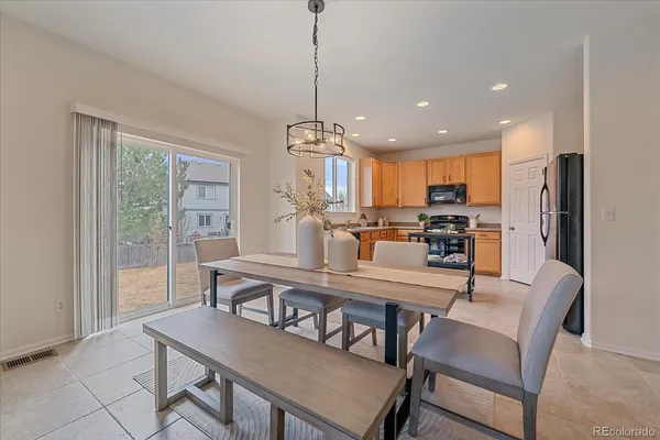 a view of a dining room and livingroom with furniture wooden floor a chandelier