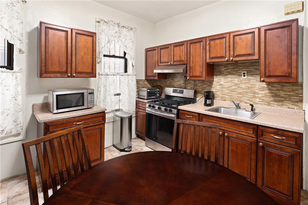 1088 Lenox Road Brooklyn, NY 11212 - Photo 9 of 9 a kitchen with stainless steel appliances granite countertop a refrigerator stove microwave and sink