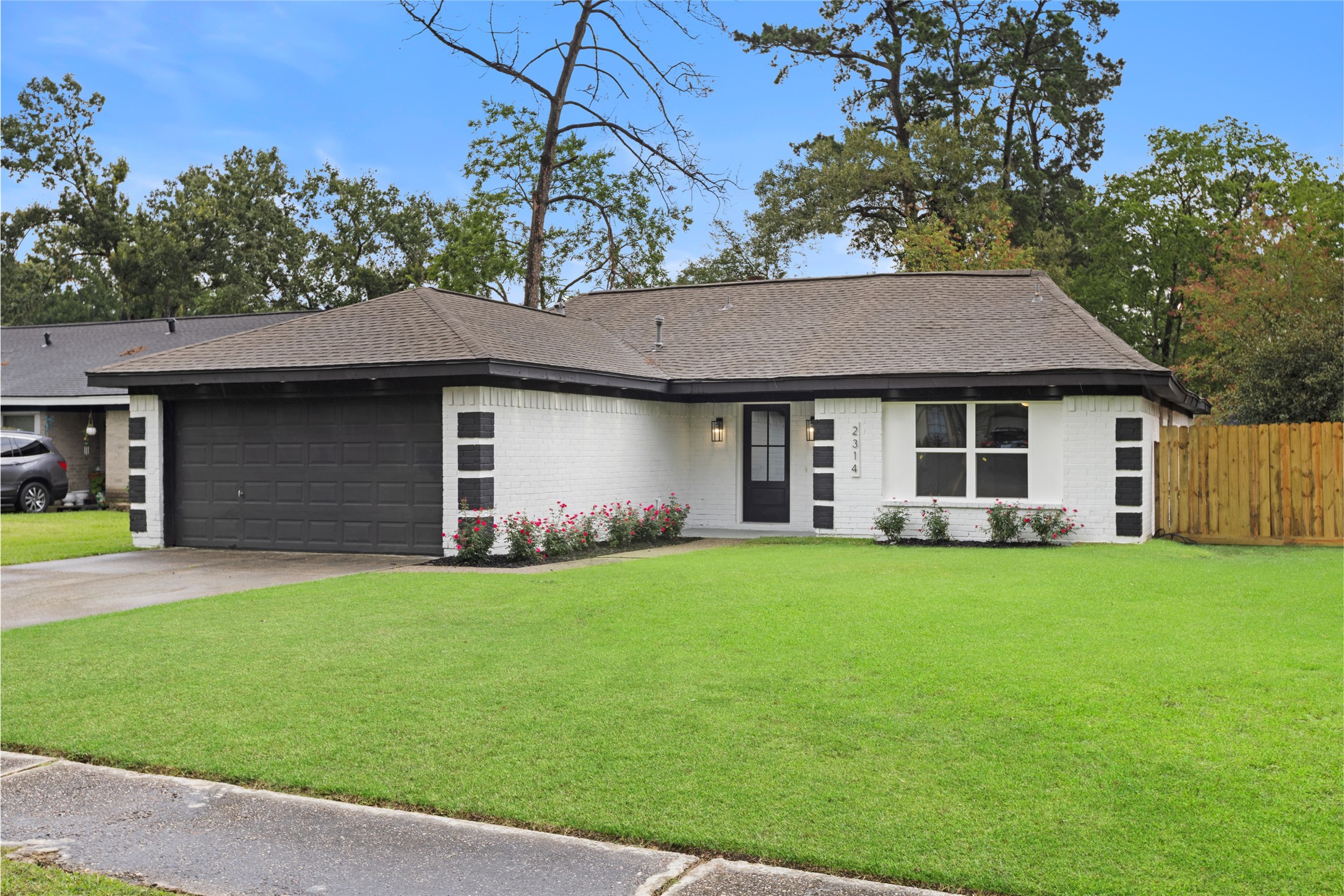 a brick house next to a yard with a large tree