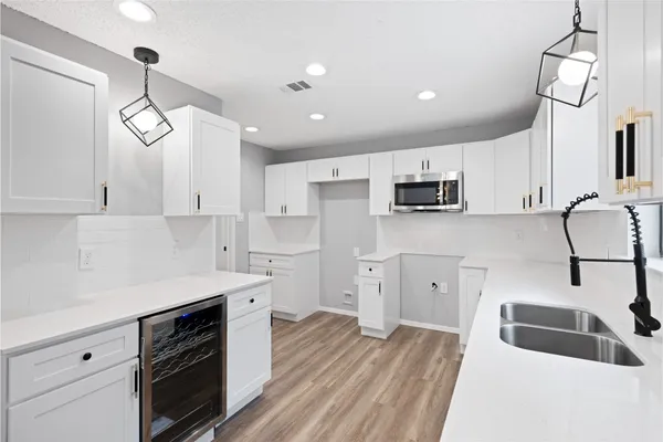 a kitchen with granite countertop a sink stainless steel appliances and white cabinets