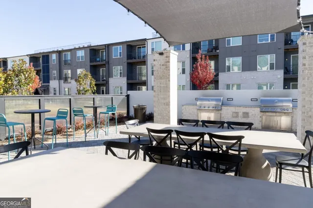 a view of a patio with table and chairs potted plants and floor to ceiling window