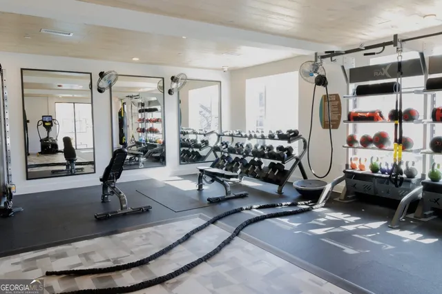 a living room with furniture a wooden floor and gym equipment