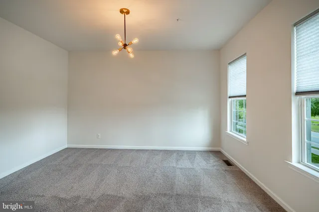 an empty room with windows and ceiling fan