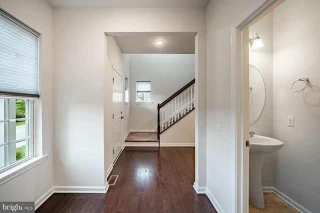 a view of a hallway with wooden floor and stairs