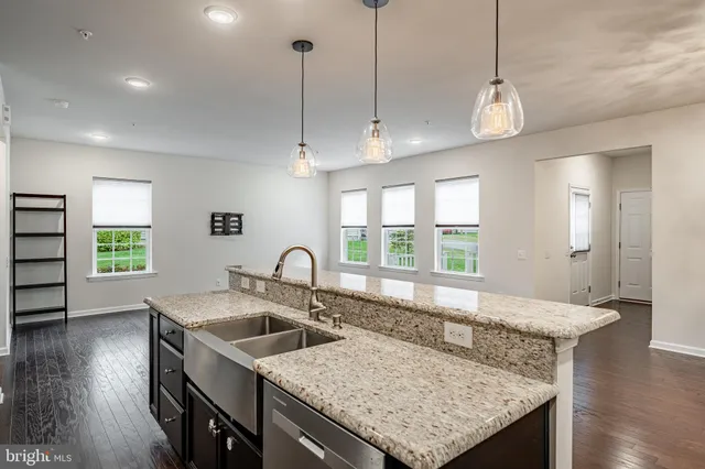 a kitchen with a stove a sink a counter space and wooden floor