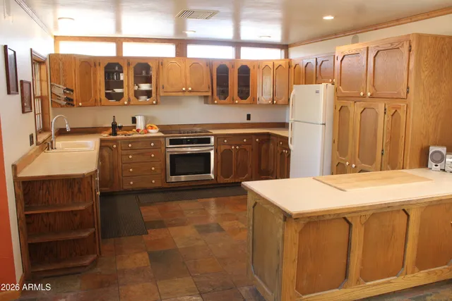 a kitchen with stainless steel appliances granite countertop a sink and a refrigerator