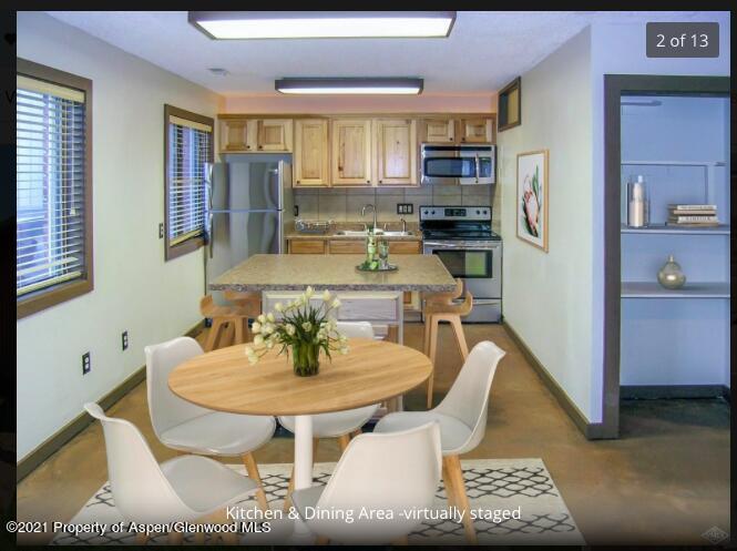 a kitchen with stainless steel appliances granite countertop a sink a stove a kitchen island and chairs